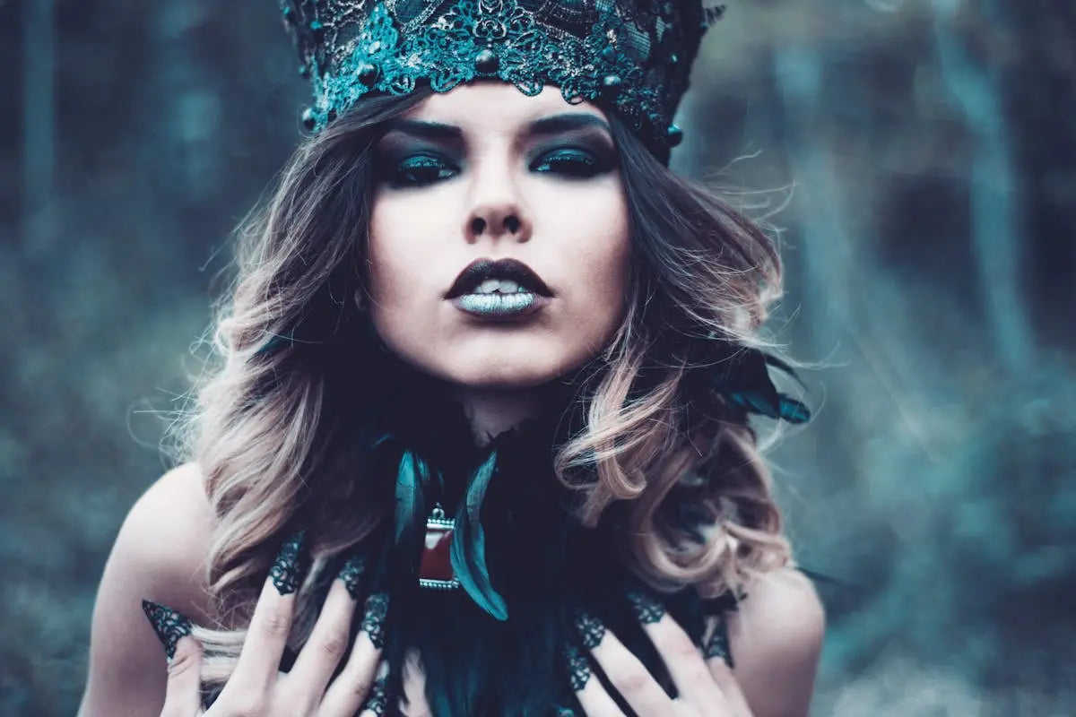 A woman wearing a crown and gloves, with dark makeup and lipstick, portrayed in a close-up fashion photography style.