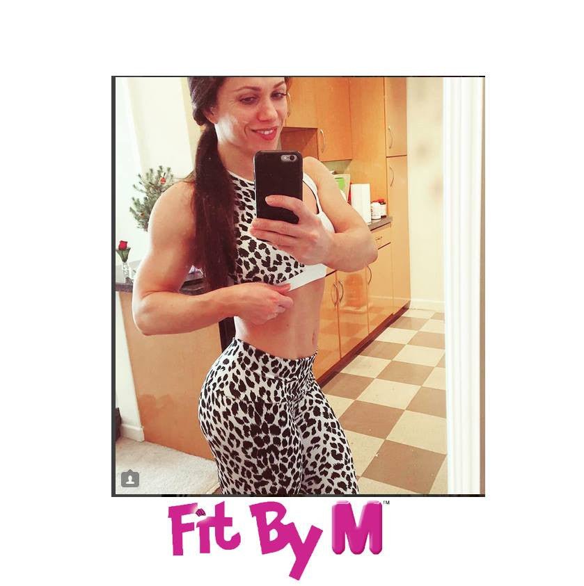 A woman is taking a selfie in front of a mirror, highlighting her pregnant belly, with a finger pointing at the cell phone.