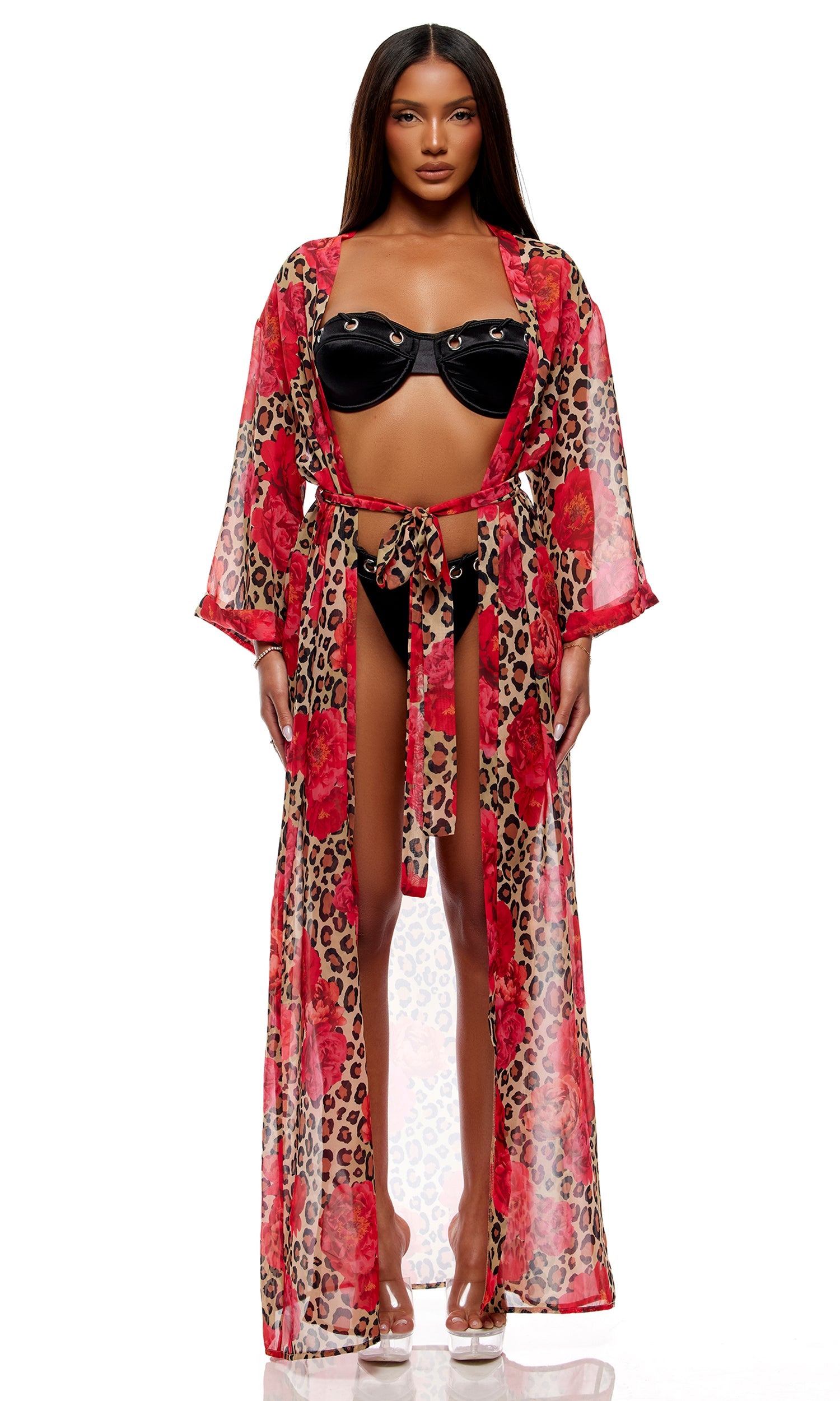 Woman modeling the Puglia Bikini Set - Black, featuring a bandeau top with underwire whipstitch grommet cups, cheeky bottoms, and a sheer leopard-print kimono with red floral motifs.