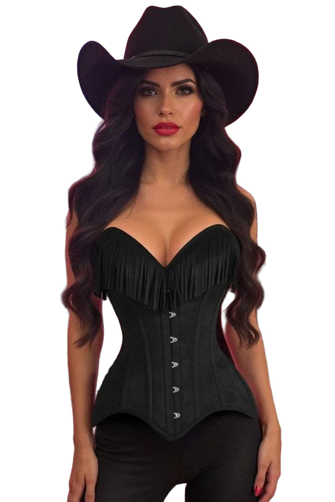 Woman in a dim social setting wearing the Top Drawer Black Suede Steel Boned Overbust Corset w/Fringe, featuring a sweetheart neckline and fringe detailing, styled with a cowboy hat and fitted pants.