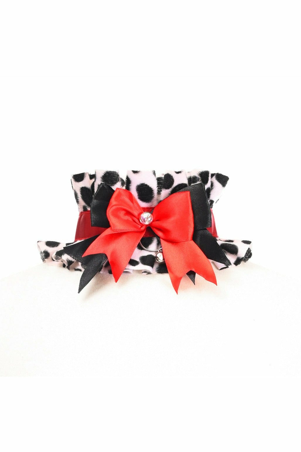 Sexy Dalmation Costume Choker featuring a black and white spotted design, with a red bow, rhinestone, and bell embellishments for a playful, glamorous touch.