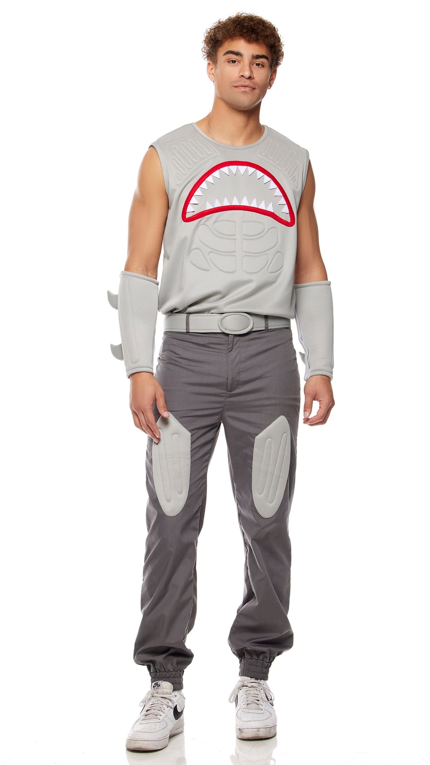 Man wearing Shark Frenzy Movie Character Costume with muscle-padded tank, 3D shark design, matching joggers, shark fin arm accessories, and belt. Close-up of white shoes.