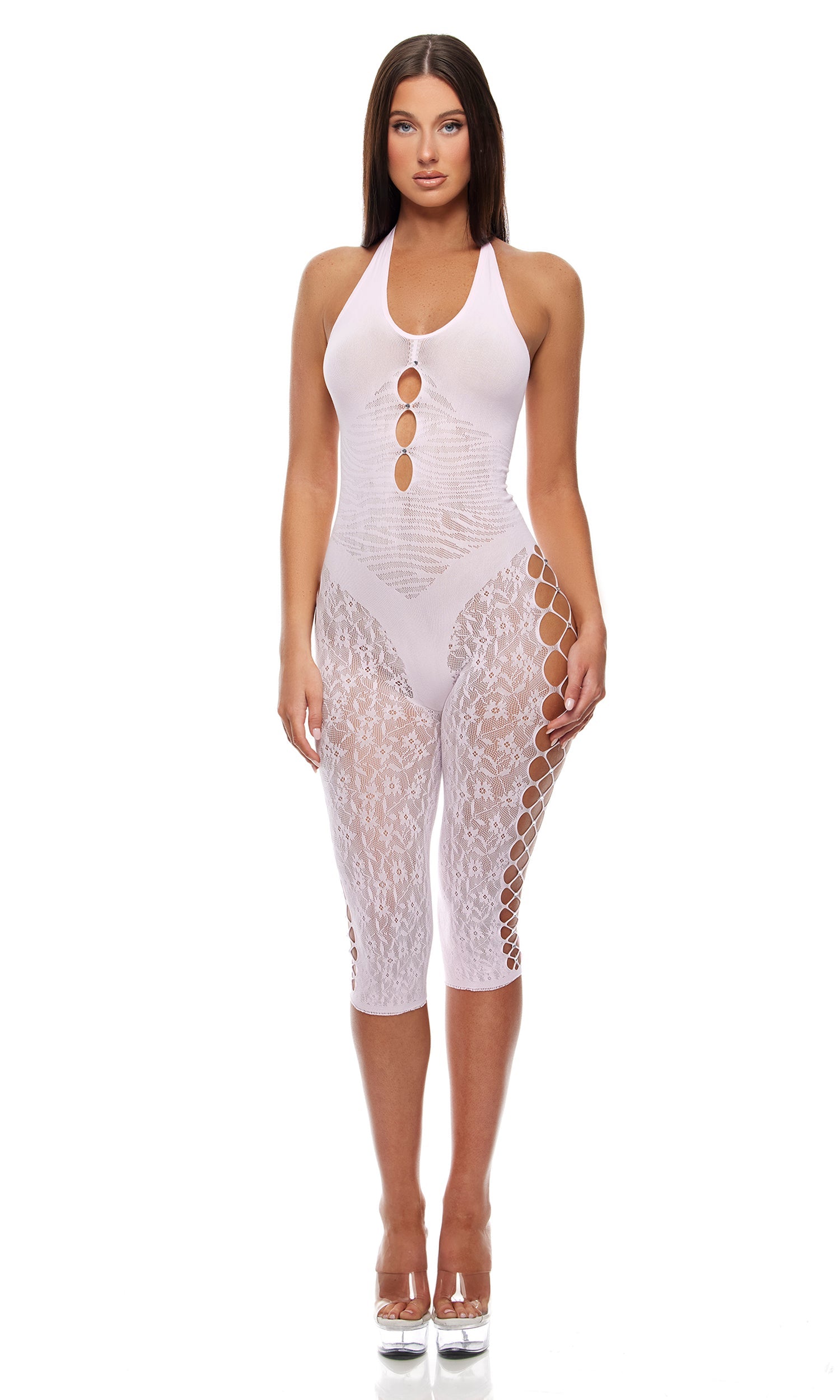 Model wearing the Cross Your Mind Capri Bodystocking - Light Pink, featuring a halter-neck design with oval cut-outs, floral lace, criss-cross latticework, and clear platform heels.
