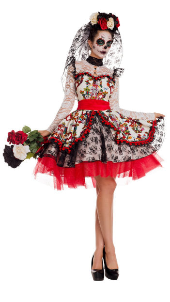 Woman wearing La Novia Day of the Dead bride dress with intricate print, lace details, ruffles, and tulle accents, holding flowers. Includes matching headpiece and waist sash.