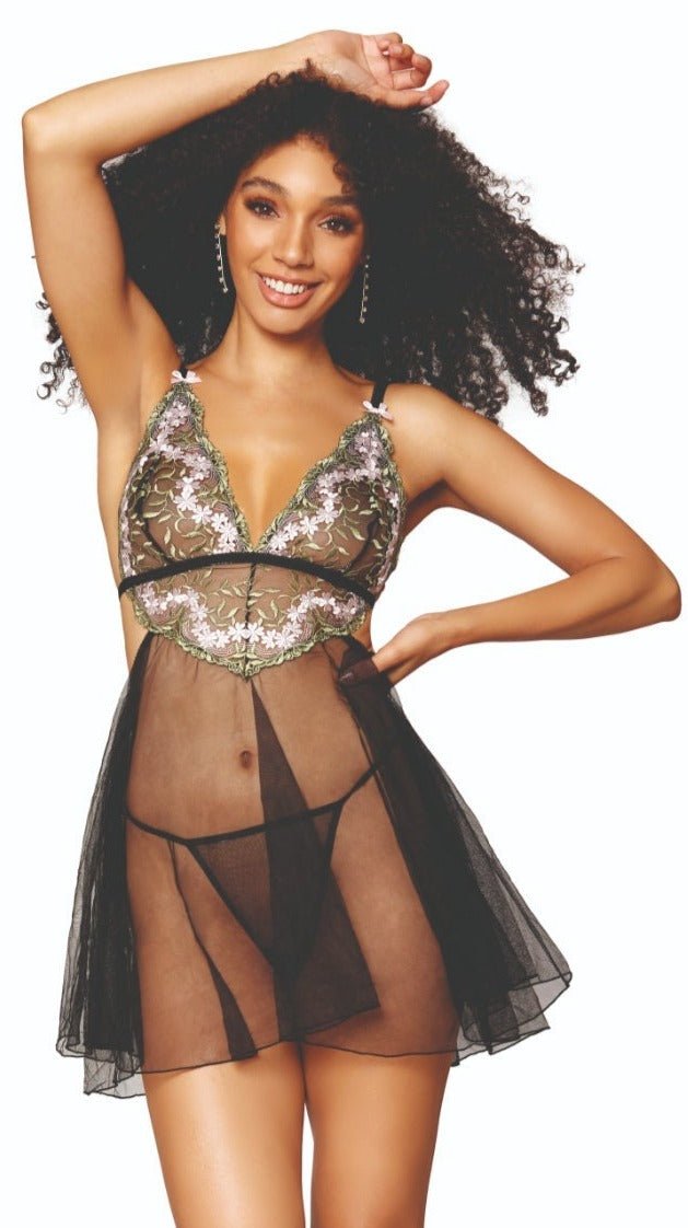 Playful Floral Embroidery Babydoll and G-string Set with mesh skirt, triangle cups, adjustable straps, cutout sides, and draped back, modeled by a woman.