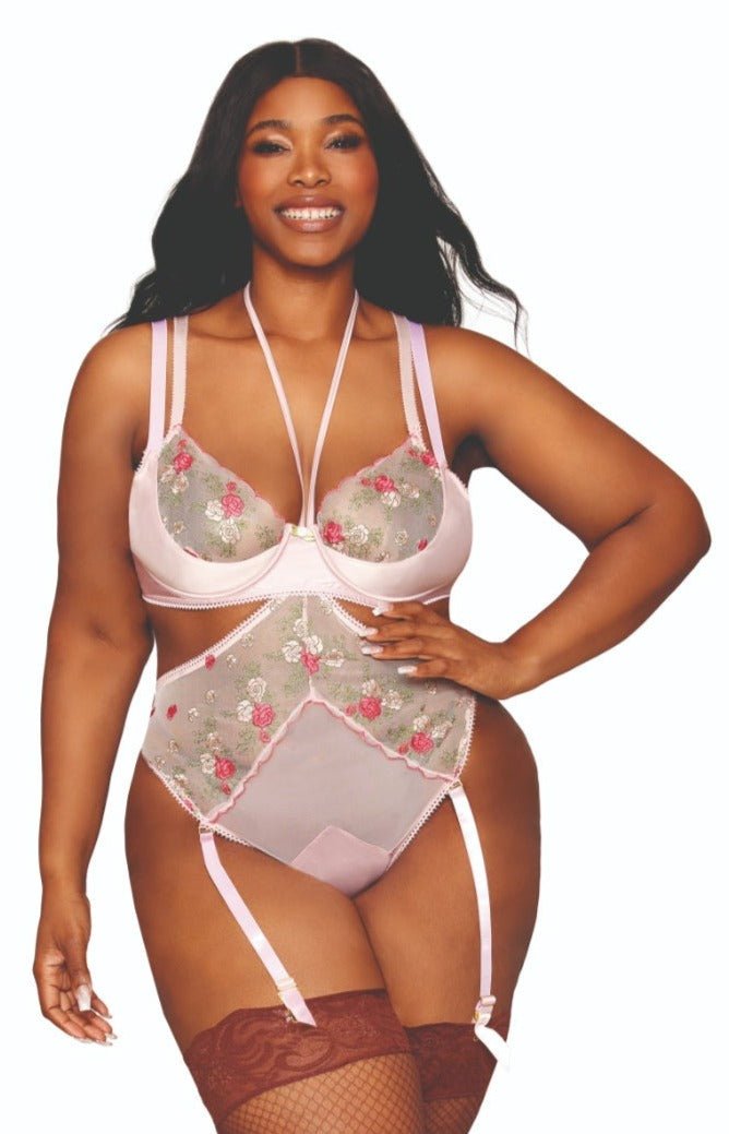 Woman modeling Vintage Rose Gala Plus Size Teddy and Bra Set, featuring sheer mesh with rose embroidery, underwire cups, adjustable straps, open cup design, and removable garters.