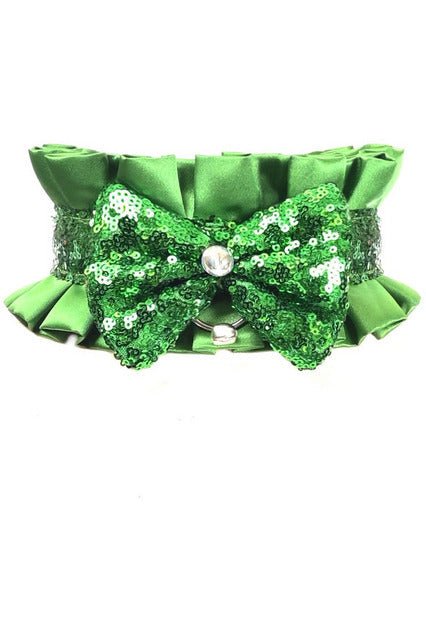 Green Satin & Sequin Costume Choker featuring a sparkling green bow with sequins, a ribbon tie closure, rhinestone embellishments, and a small decorative bell.