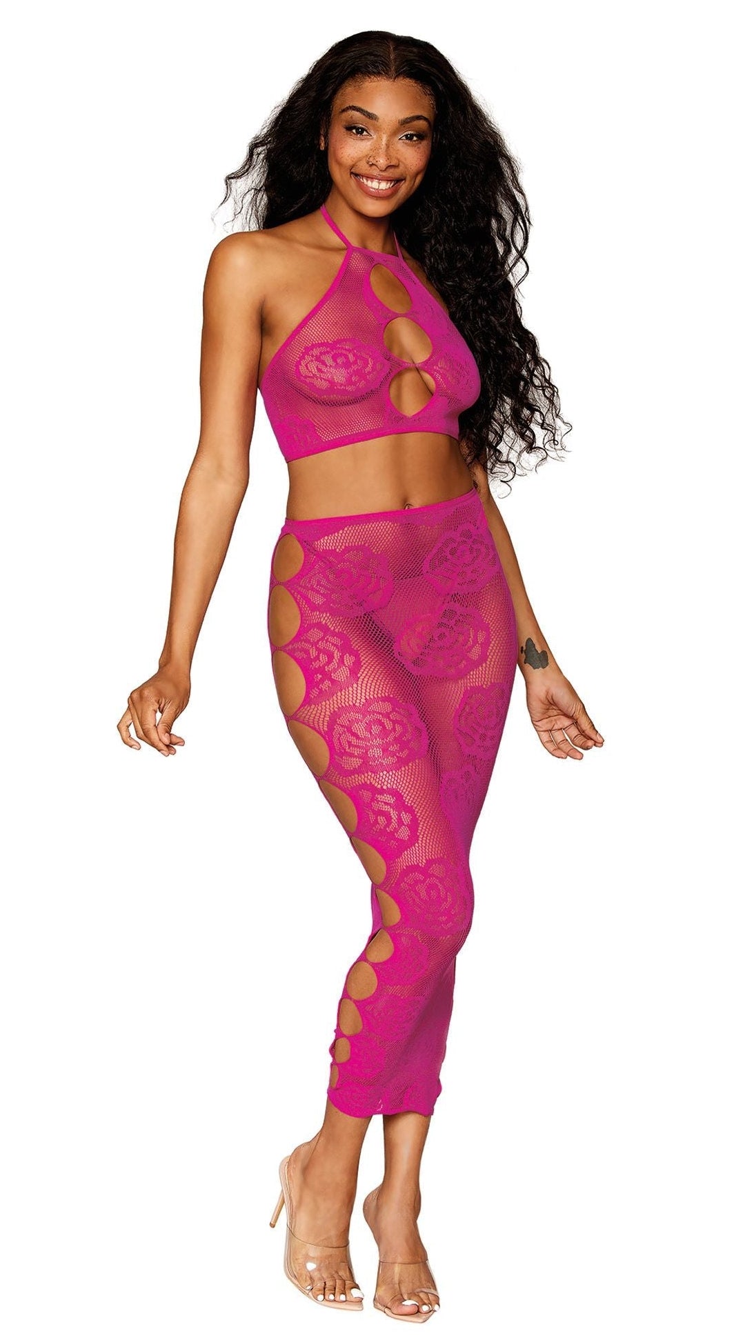 Woman modeling a Hot Pink Mesh Crop Top and Skirt Set featuring a rose and fishnet pattern with keyhole side details, exuding edgy sophistication.