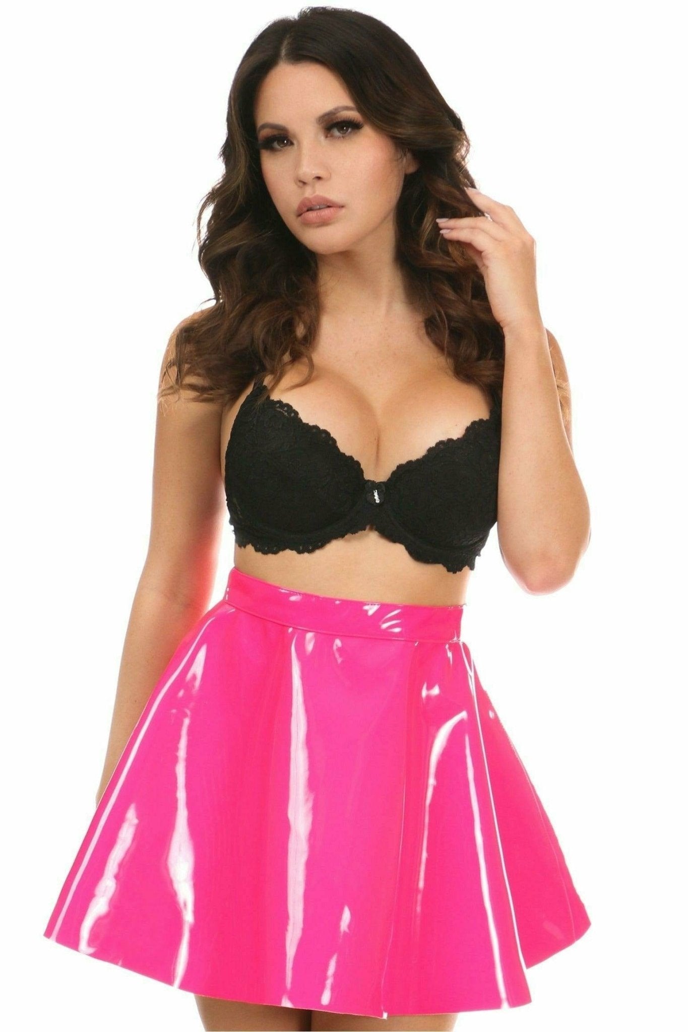 Woman modeling a Hot Pink Patent Skirt, featuring high-shine vinyl material, flared design, and back zipper with button closure for a stylish look.