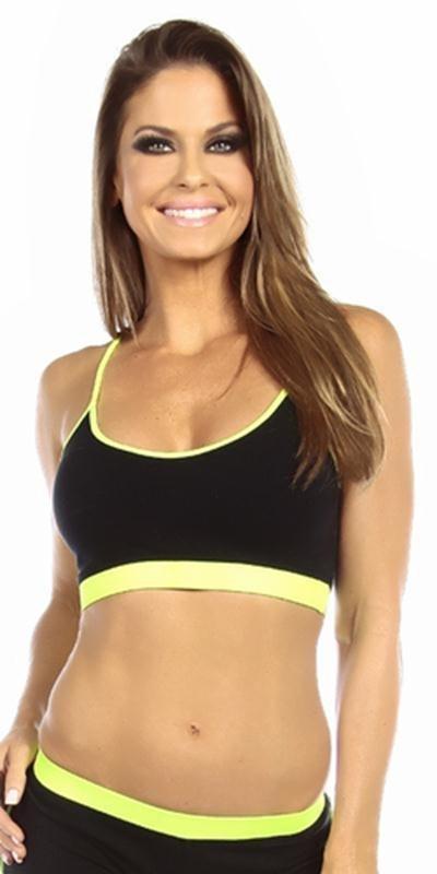 Woman modeling the Sexy Neon Trim Fit Principle Athletic Crop Sports Bra Top in black with neon yellow trim, smiling confidently at the camera.