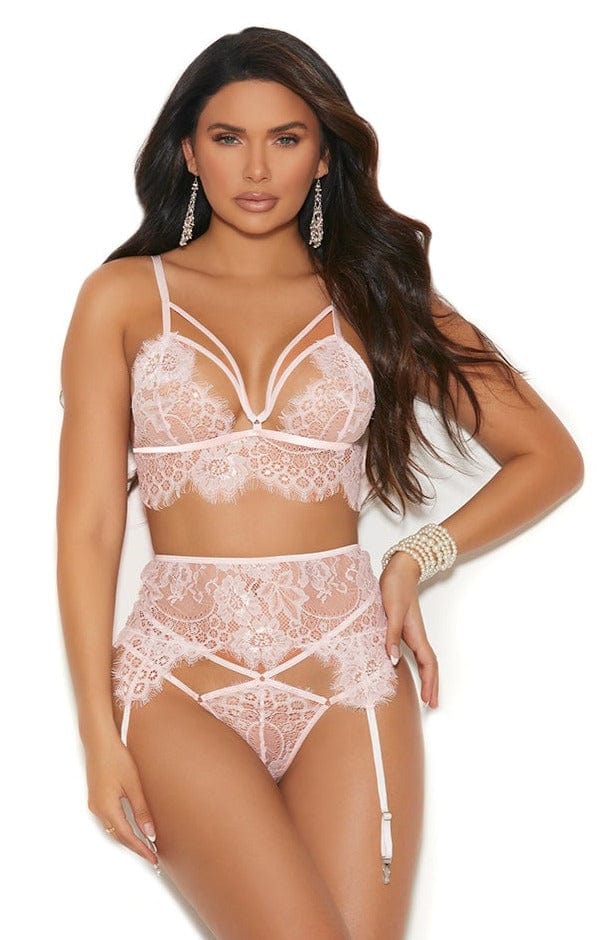 Woman modeling the Sexy Pure Blush Lace Bra, Panty and Garterbelt set, featuring strappy details, eyelash lace, adjustable straps, and garterbelt with adjustable straps.