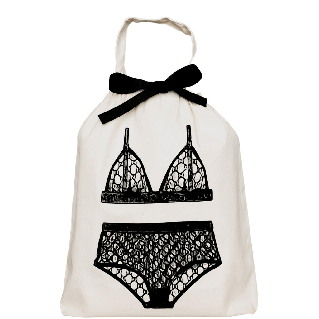 The Feeling Shy Bundle, featuring a white bag with a black bow, includes selected panties and hosiery, highlighting fashion accessories with a black and white garment.